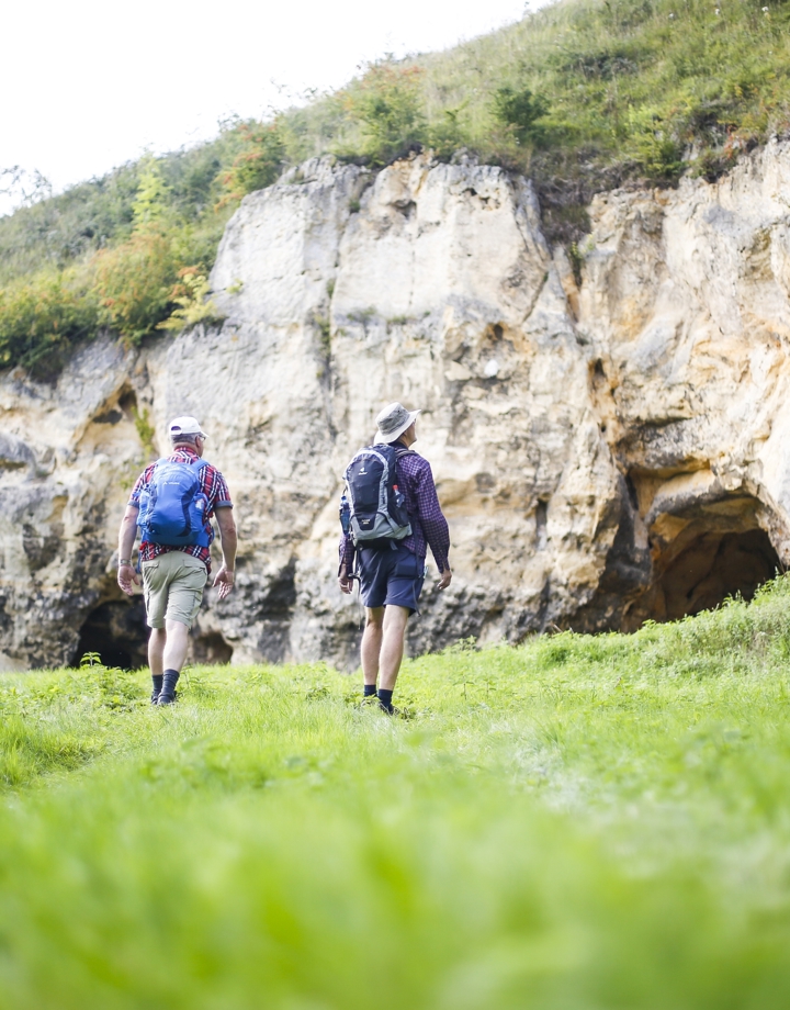 Twee mannen lopen langs een indrukwekkende krijtwand