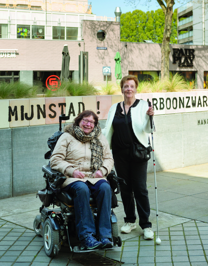 Foto Inclusie Audioroute Heerlen, twee dames, een in een elektrische rolstoel en een met een blinde stok